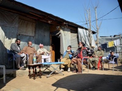 This photograph taken on February 12, 2017, shows elderly Indian Kashmiri Muhammad Ashraf (2L), flanked by his son Muhammad Asghar (L), as he meets with his childhoood friend Muhammad Sharif (R) upon his arrival at a refugee camp on the outskirts of Muzaffarabad. PHOTO: AFP