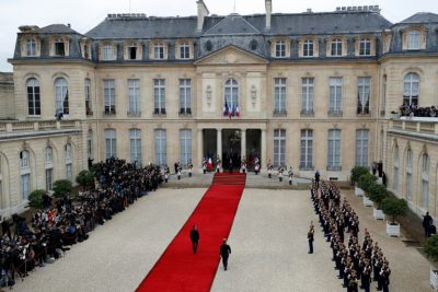 France's newly elected president Emmanuel Macron is welcomed by his predecessor Francois Hollande (C) as he arrives at the Elysee presidential Palace in Paris for the handover and inauguration ceremonies on May 14, 2017