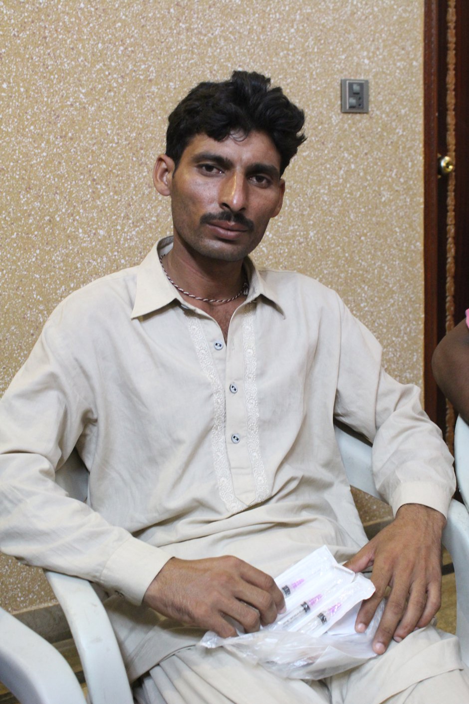 A worker with his medicines and report of Malaria after whose contraction he was fired by the company.